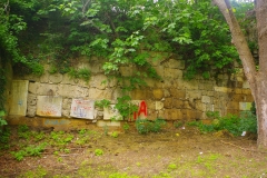 North wall with spolia visible, including an inscription at left.